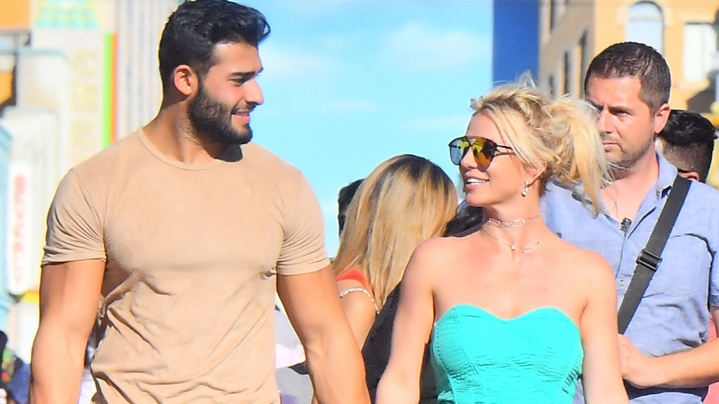 Britney Spears and her boyfriend Sam Asghari hold hands while out celebrating her sons' birthdays at Disneyland