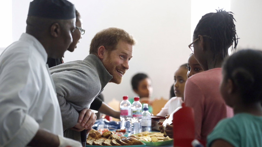 Prince Harry serves food to children as part of the Fit and Fed initiative in London