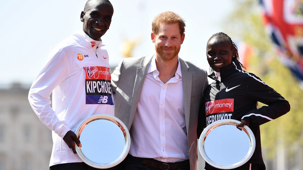 Prince Harry poses with Eliud Kipchoge of Kenya and Vivian Cheruiyot of Kenya as they receive their trophies, following their first place results during the Virgin Money London Marathon at United Kingdom on April 22, 2018 in London, England.