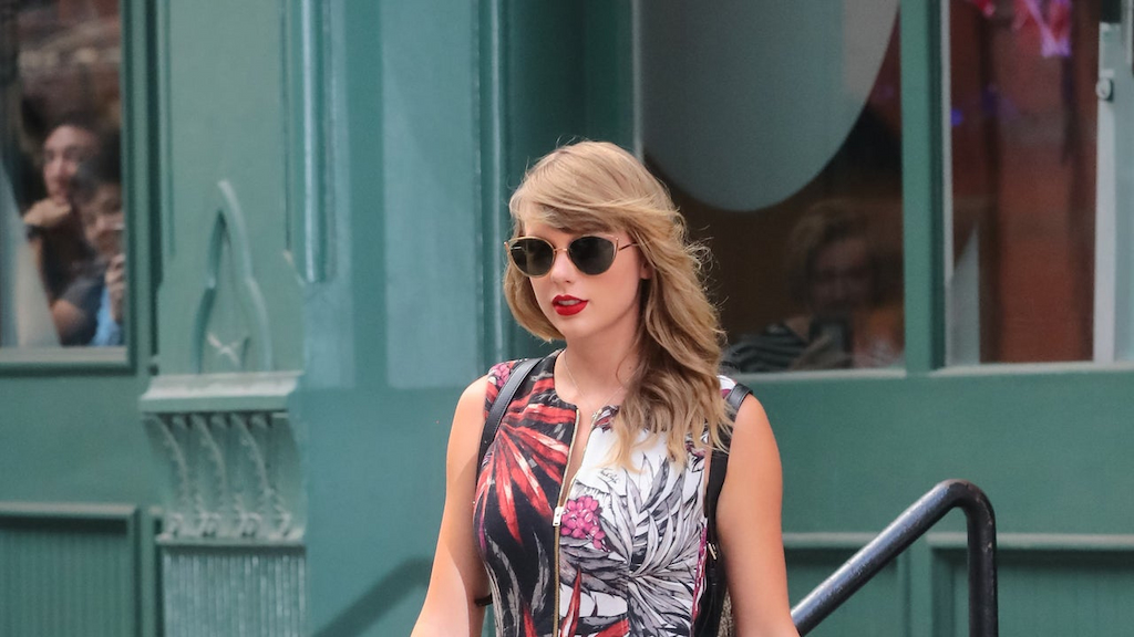 Taylor Swift in printed romper and snakeskin backpack and platform boots