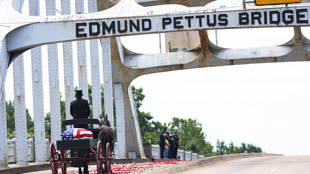 A horse drawn carriage carrying the body of civil rights icon, former US Rep. John Lewis (D-GA) crosses the Edmund Pettus Bridge as it prepares to pass members of his family on July 26, 2020 in Selma, Alabama. On the second of six days of ceremonies, Lewis’s funeral procession continues to follow the Selma to Montgomery National Historic Trail on its way to the State Capitol where he will lie in state. On March 7, 1965 Lewis and other civil rights leaders were attacked by Alabama State Police while marching