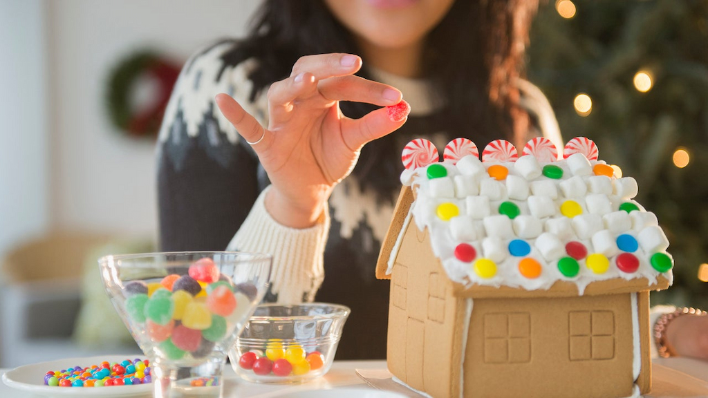 Woman decorating gingerbread house