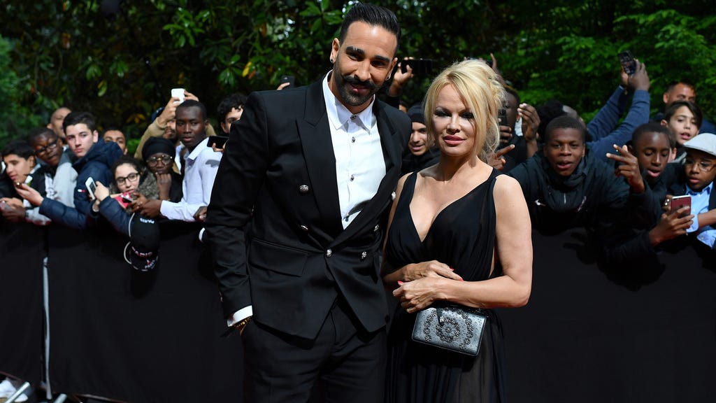 Adil Rami and Pamela Anderson arrive to take part in a TV show on May 19, 2019 in Paris, as part of the 28th edition of the UNFP (French National Professional Football players Union) trophy ceremony.