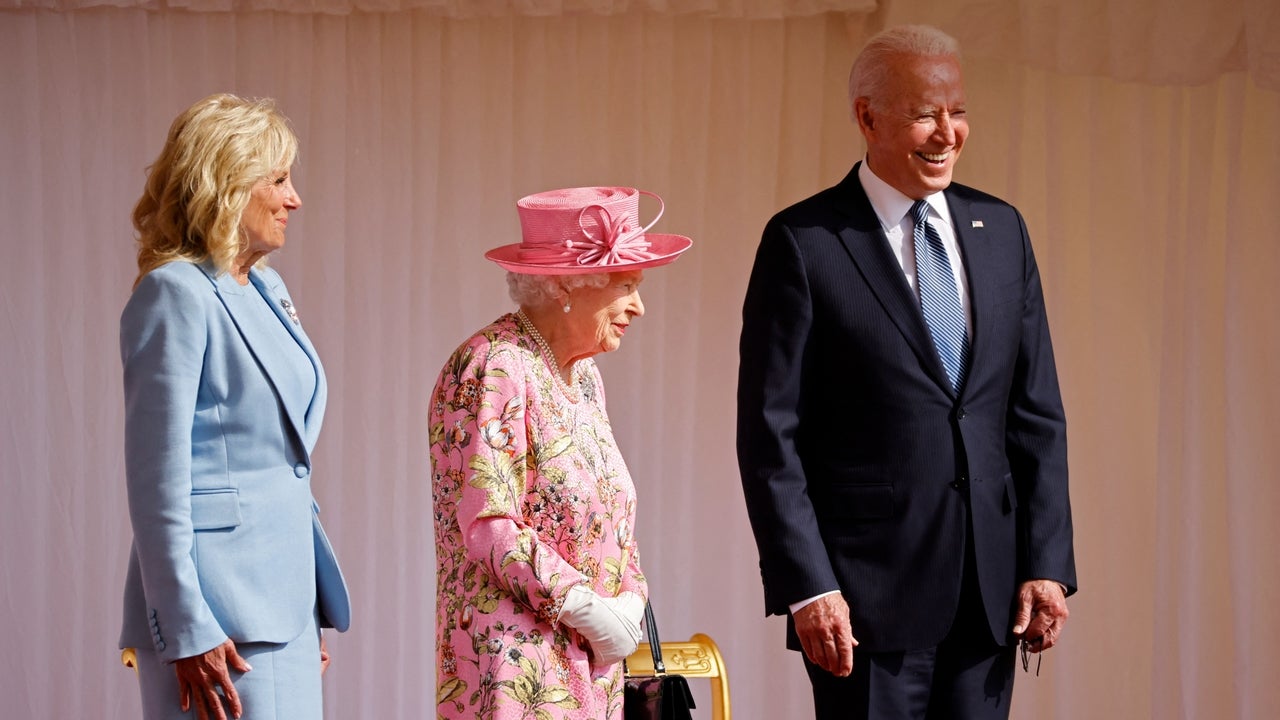 US President Joe Biden (R) and US First Lady Jill Biden (L) share a joke with with Britain's Queen Elizabeth II (C) before watching the military march past at Windsor Castle in Windsor, west of London, on June 13, 2021. - US president Biden will visit Windsor Castle late Sunday, where he and First Lady Jill Biden will take tea with the queen. 