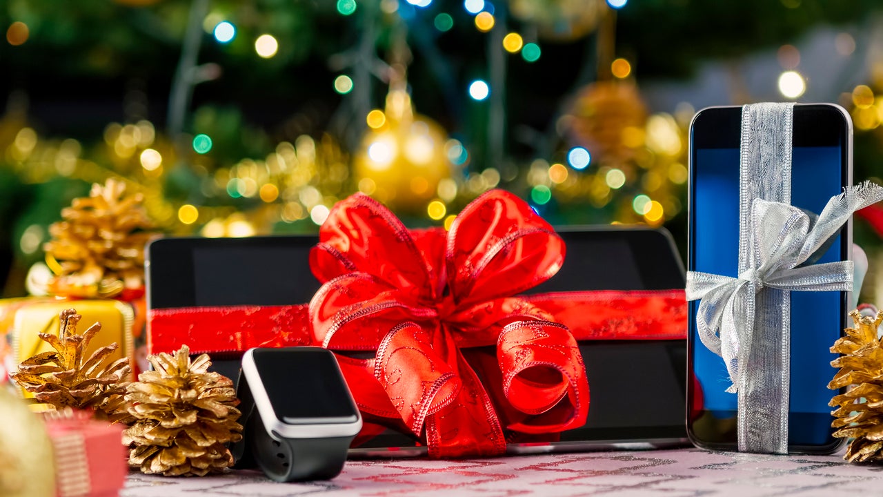 tablet and cellphone wrapped under christmas tree