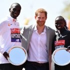 Prince Harry poses with Eliud Kipchoge of Kenya and Vivian Cheruiyot of Kenya as they receive their trophies, following their first place results during the Virgin Money London Marathon at United Kingdom on April 22, 2018 in London, England.