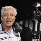 English actor David Prowse (L), who played the character of Darth Vader (Dark Vador in French) in the first Star Wars trilogy poses with a fan dressed up in a Darth Vader costume during a Star Wars convention on April 27, 2013 in Cusset.