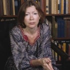 Portrait of American author Joan Didion as she sits in a chair in front of a bookshelf, Berkeley, California, April 1981. 