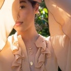 Woman in flowy top wearing Bridgerton Jewelry