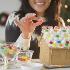 Woman decorating gingerbread house