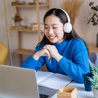 Woman using laptop with headphones