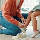 mom putting on daughter's sneakers