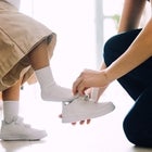 mom putting son's shoes on