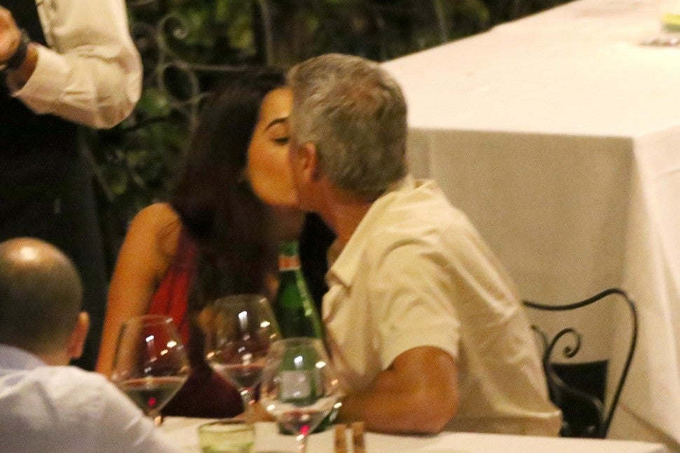 George and Amal Clooney kissing at dinner in Italy