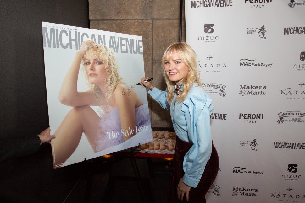 Malin Akerman signs cover of Michigan Avenue