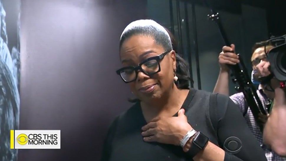 Oprah Winfrey cries as she tours the Smithsonian exhibit dedicated to her.