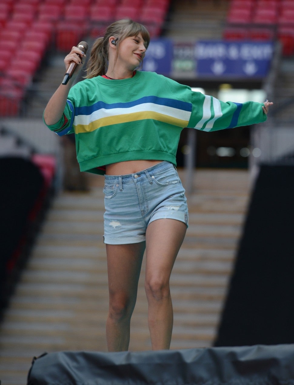 Taylor Swift in green sweater and denim shorts
