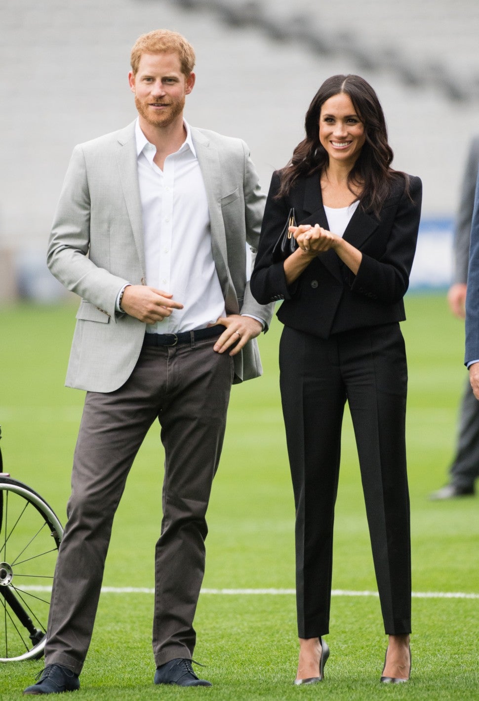 Meghan Markle in black pantsuit with Prince Harry on soccer field