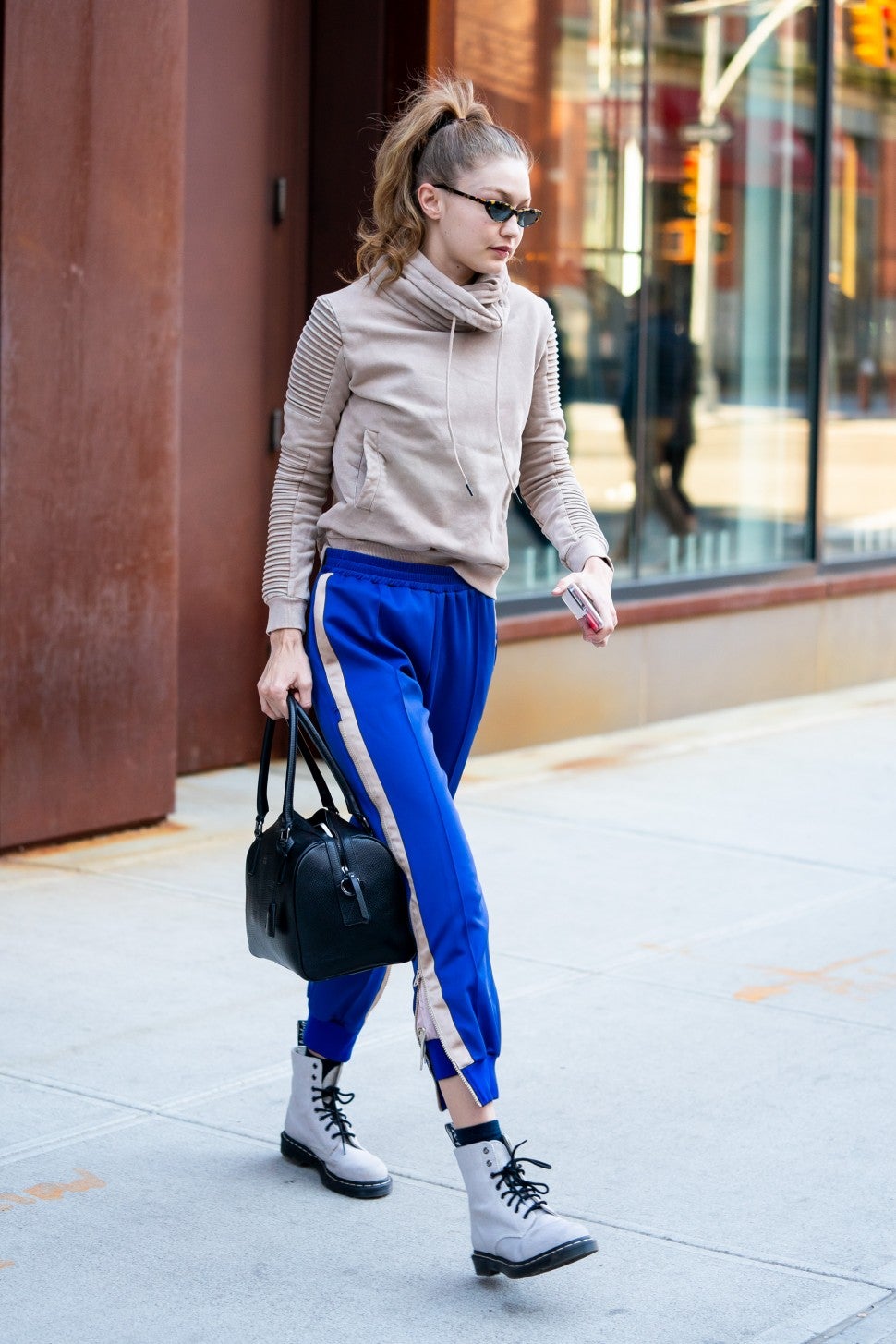 Gigi Hadid in blue sweatpants and lace-up boots