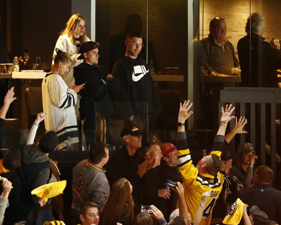 Justin Bieber and wife Hailey Rhode Bieber look on as fans Boston Bruins fans celebrate during the third period of Game Seven of the Eastern Conference First Round during the 2019 NHL Stanley Cup Playoffs between the Boston Bruins and the Toronto Maple Leafs at TD Garden on April 23, 2019 in Boston, Massachusetts.