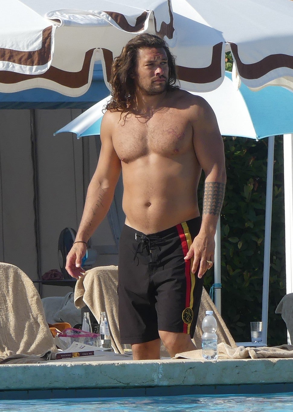 Jason Momoa shows off his ripped torso as she gets ready for a dip in the pool. The actor had his bulging biceps on display as he and wife Lisa Bonet were spotted on their romantic vacation in Venice.