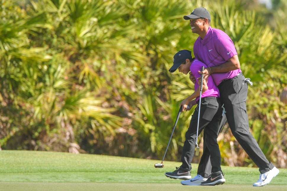 Tiger Woods hugs his son Charlie Woods after making an eagle on the third green during the first round of the PGA TOUR Champions PNC Championship at Ritz-Carlton Golf Club on December 19, 2020 in Orlando, Florida. 