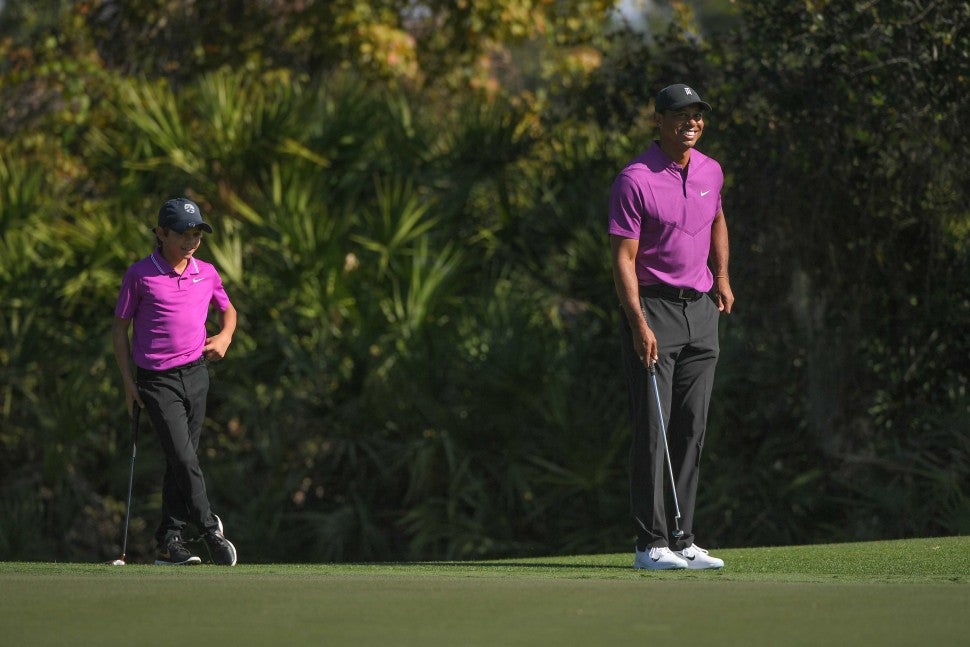 Tiger Woods and his son Charlie Woods stand together on the third green during the first round of the PGA TOUR Champions PNC Championship at Ritz-Carlton Golf Club on December 19, 2020 in Orlando, Florida.