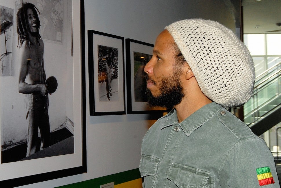 Ziggy Marley next to photo of dad Bob Marley