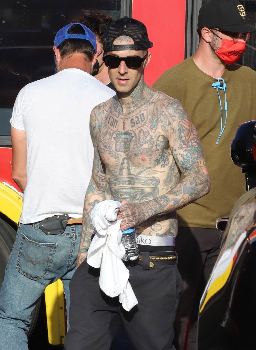 Travis Barker seen sporting a new Kourtney tattoo over his heart as he plays the drums for a video on top a Hollywood tour bus.