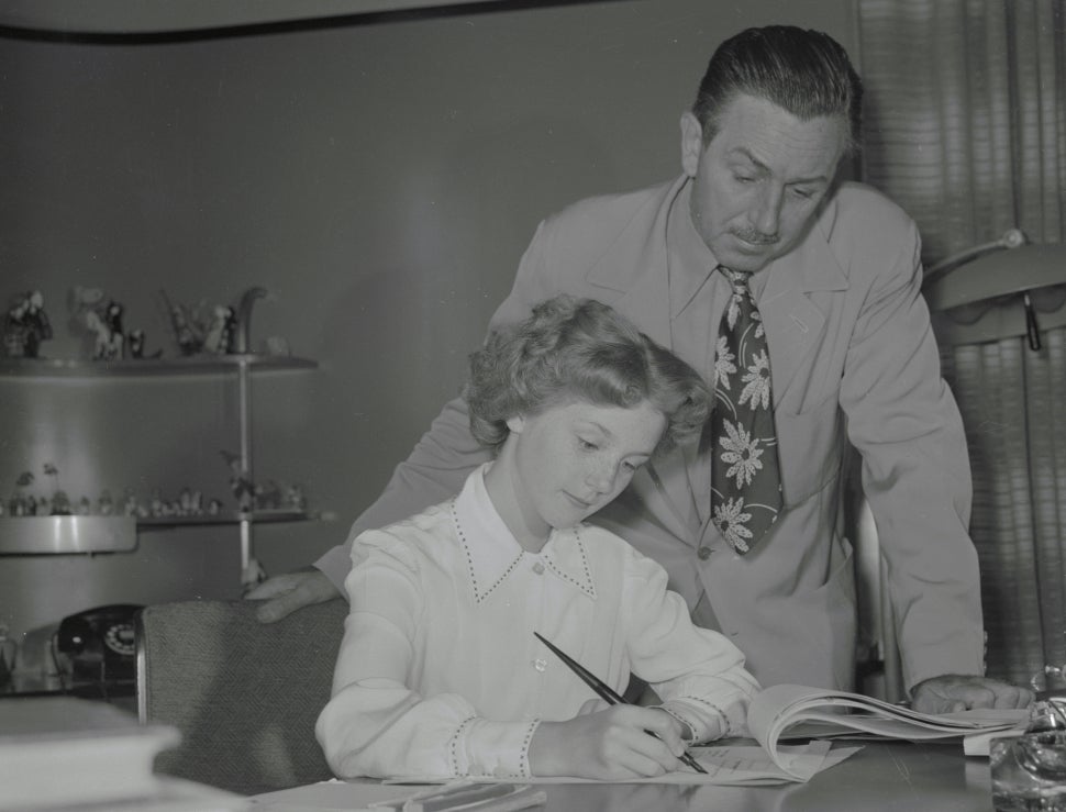 Walt Disney observes Kathryn Beaumont signing her contract to play Alice.
