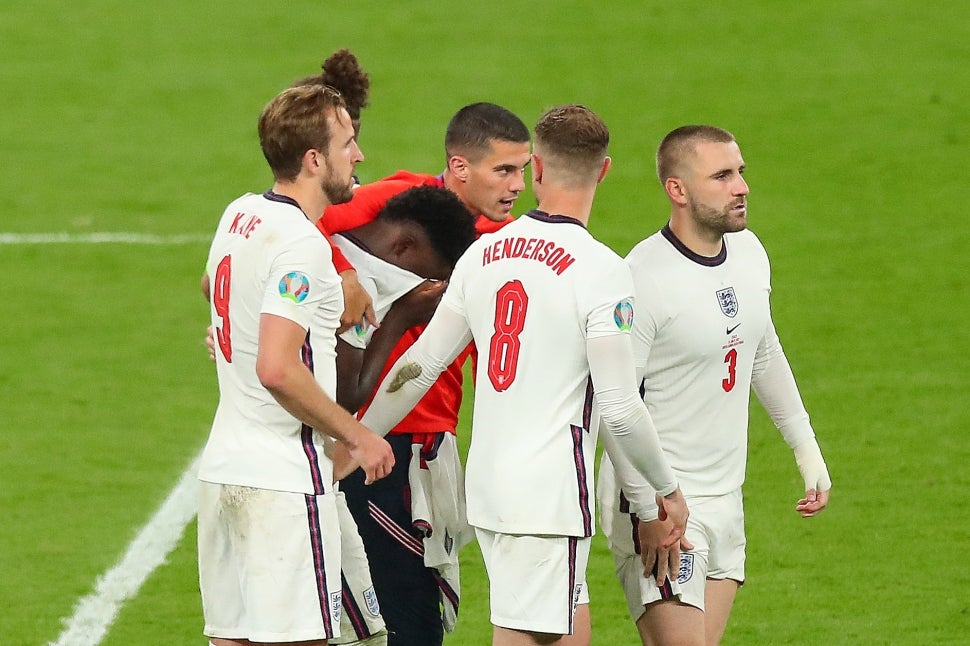 Bukayo Saka of England is consoled by team mates after missing the decisive penalty during the UEFA Euro 2020 Championship Final between Italy and England at Wembley Stadium on July 11, 2021 in London, United Kingdom.