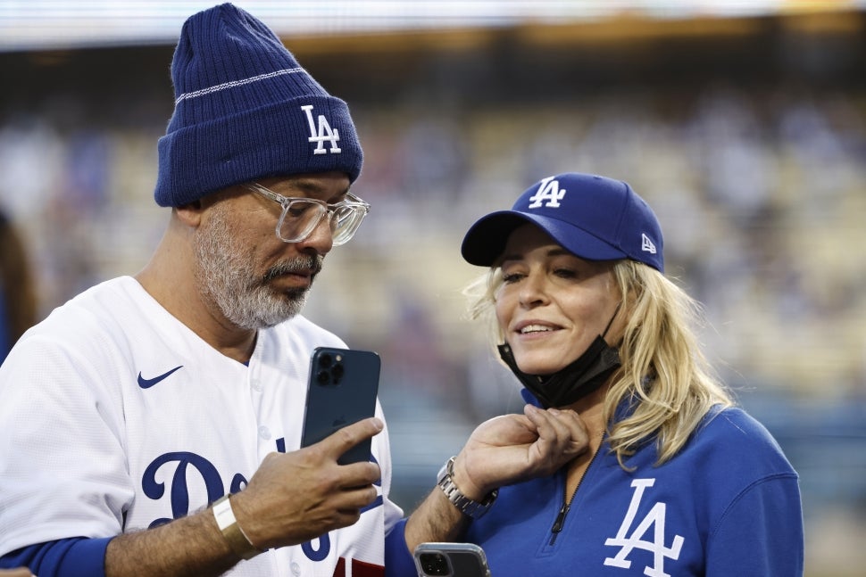 Comedian Jo Koy (L) and Comedian/actress Chelsea Handler (R) takes a selfie prior to a game between the Los Angeles Dodgers and the Atlanta Braves at Dodger Stadium on August 31, 2021 in Los Angeles, California.