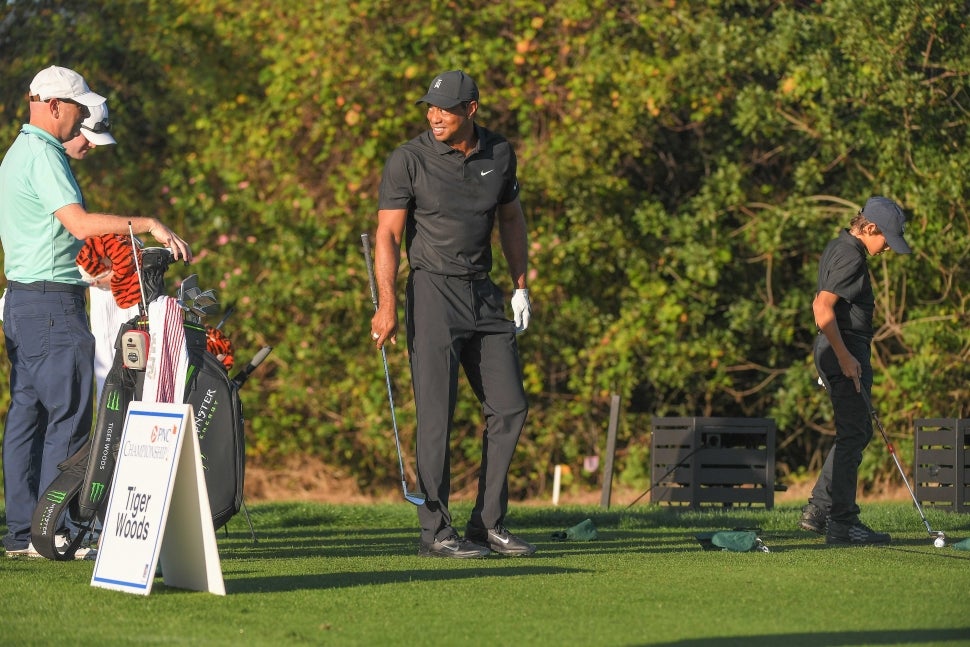 Tiger Woods and his son, Charlie Woods, warm up on the range during the PGA TOUR Champions Friday Pro-am at PNC Championship at Ritz-Carlton Golf Club on December 17, 2021 in Orlando, Florida.