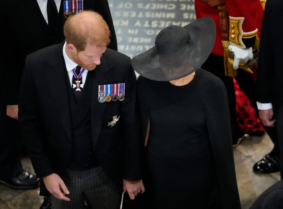 Prince Harry, Duke of Sussex and Meghan, Duchess of Sussex follow the coffin of Queen Elizabeth II as it is carried out of Westminster Abbey