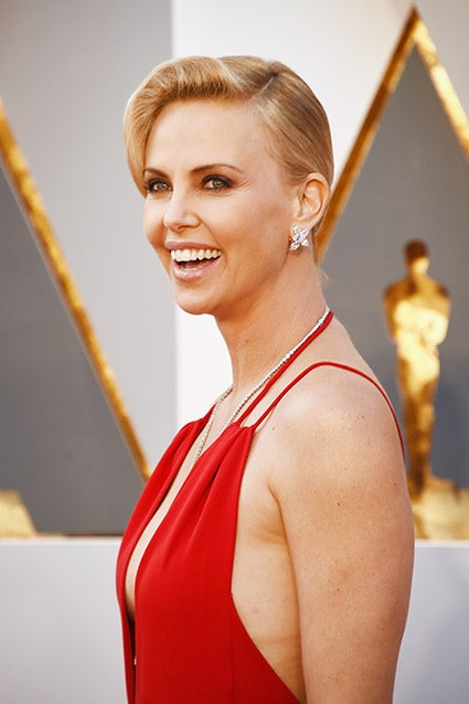 charlize theron red dress Our only note? She should've had the gloves on!  Charlize Theron snapped  this glamorous topless photo before donning her Givenchy gown and epic  leather Bonbon gloves for 'The Odyssey' premiere in
