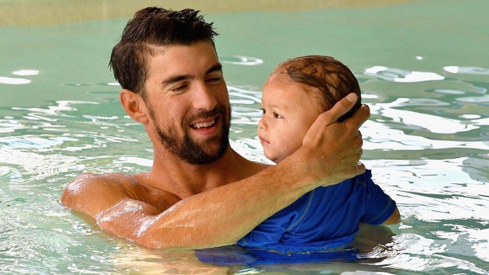 Michael Phelps swims in a pool with son Boomer.