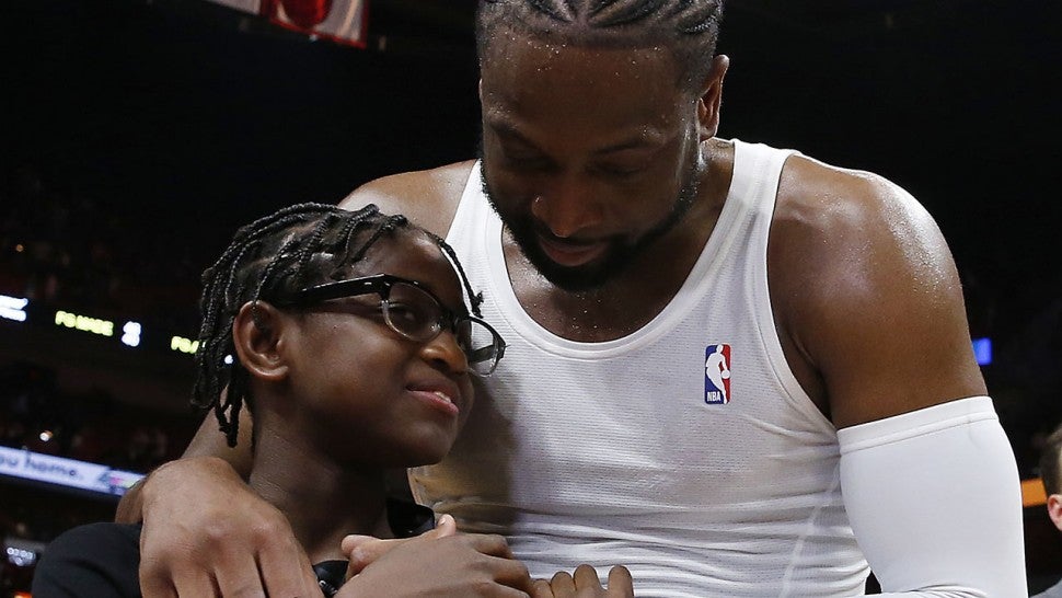 Dwyane Wade hugs Zaya after his final career home game at American Airlines Arena on April 09, 2019 in Miami, Florida