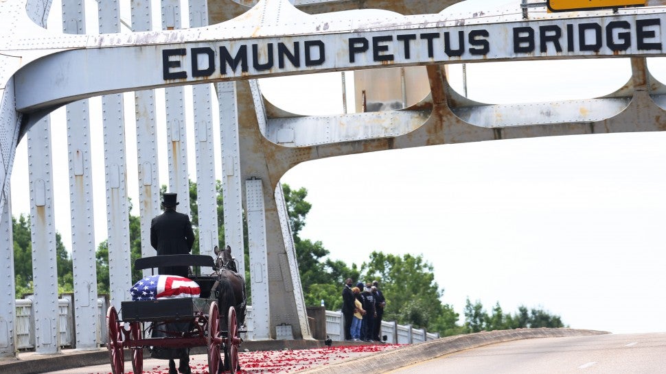 A horse drawn carriage carrying the body of civil rights icon, former US Rep. John Lewis (D-GA) crosses the Edmund Pettus Bridge as it prepares to pass members of his family on July 26, 2020 in Selma, Alabama. On the second of six days of ceremonies, Lewis’s funeral procession continues to follow the Selma to Montgomery National Historic Trail on its way to the State Capitol where he will lie in state. On March 7, 1965 Lewis and other civil rights leaders were attacked by Alabama State Police while marching