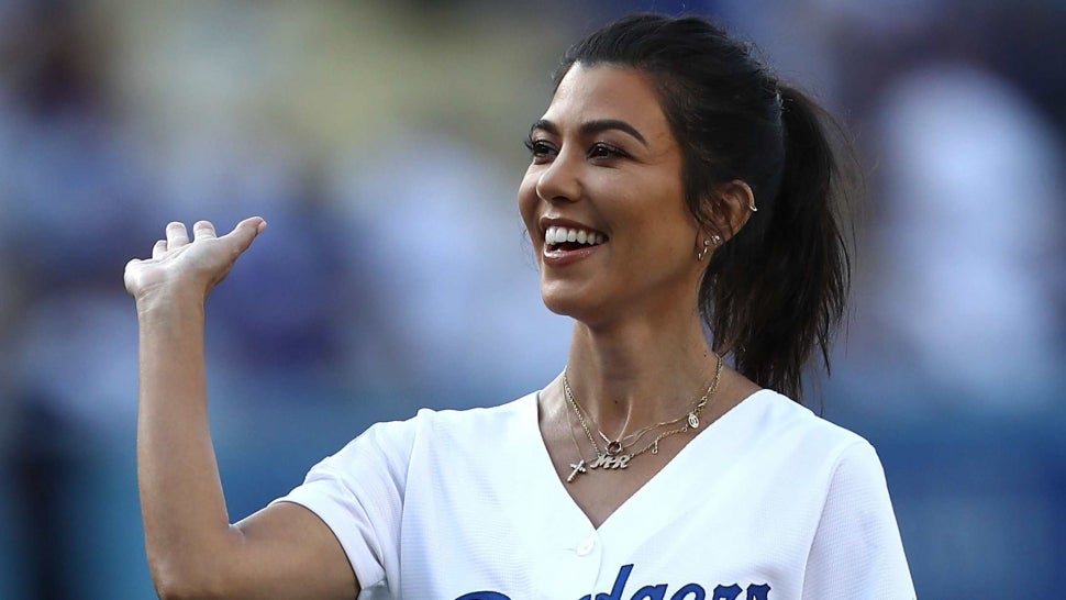 Kourtney Kardashian looks to give a high-fiven after throwing out the ceremonial first pitch prior to the MLB game at Dodger Stadium on August 2, 2018 in Los Angeles, California. The Dodgers defeated the Brewers 21-5.