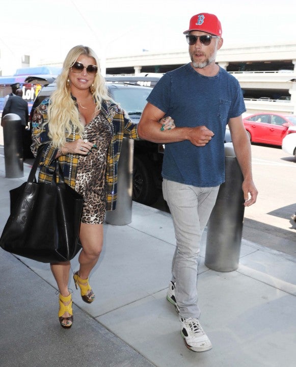 Jessica Simpson and husband Eric Johnson walk through LAX airport on July 30.
