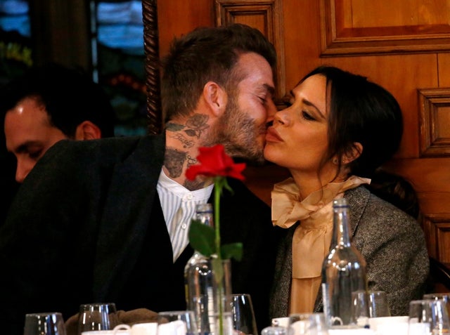 David Beckham and Victoria Beckham kiss at fashion show in London