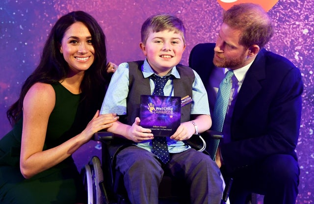 Prince Harry and Meghan Markle pose for a photo with award winner William Magee during the WellChild Awards