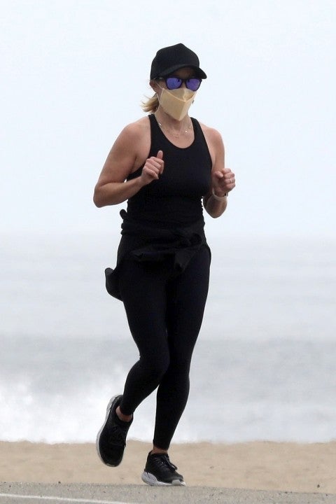 Reese Witherspoon jogs on beach in malibu