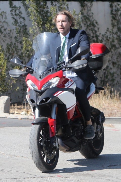 dax shepard rides his ducati in a suit