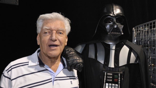 English actor David Prowse (L), who played the character of Darth Vader (Dark Vador in French) in the first Star Wars trilogy poses with a fan dressed up in a Darth Vader costume during a Star Wars convention on April 27, 2013 in Cusset.