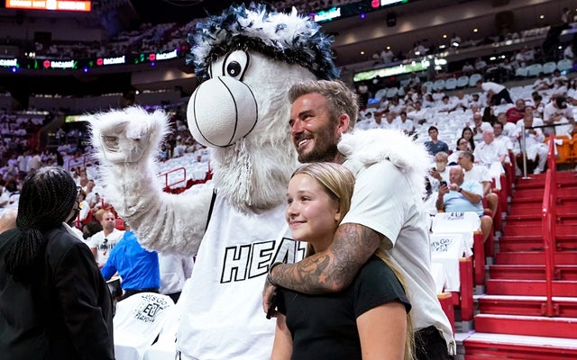 David Beckham and his daughter Harper Seven Beckham pose for a photo with the Miami Heat mascot Burnie during the first half of Game 2 of an NBA basketball first-round playoff series between the Miami Heat and Atlanta Hawks, Tuesday, April 19, 2022, in Miami.
