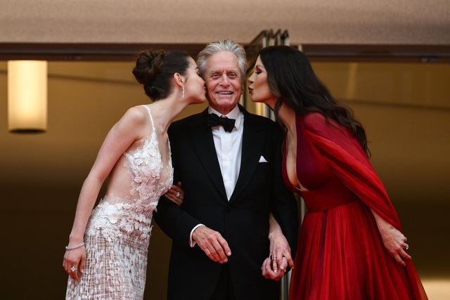 Catherine Zeta-Jones (R) and her daughter Carys kiss US actor and Honorary Palme d'or of the 76th Festival de Cannes Michael Douglas