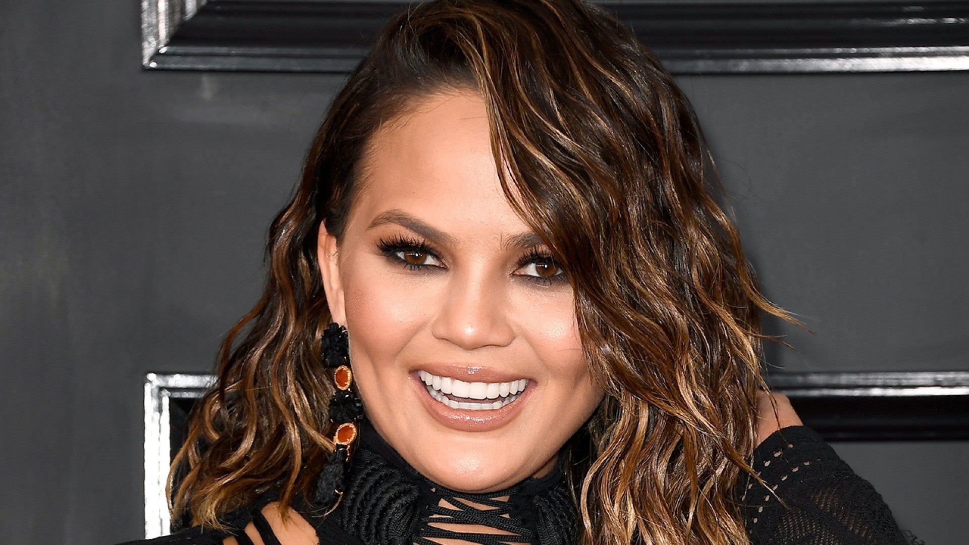 Chrissy Teigen S Boobs Can T Fit In Her Jumpsuit Watch Her Hilariously Try To Squeeze Them In Entertainment Tonight